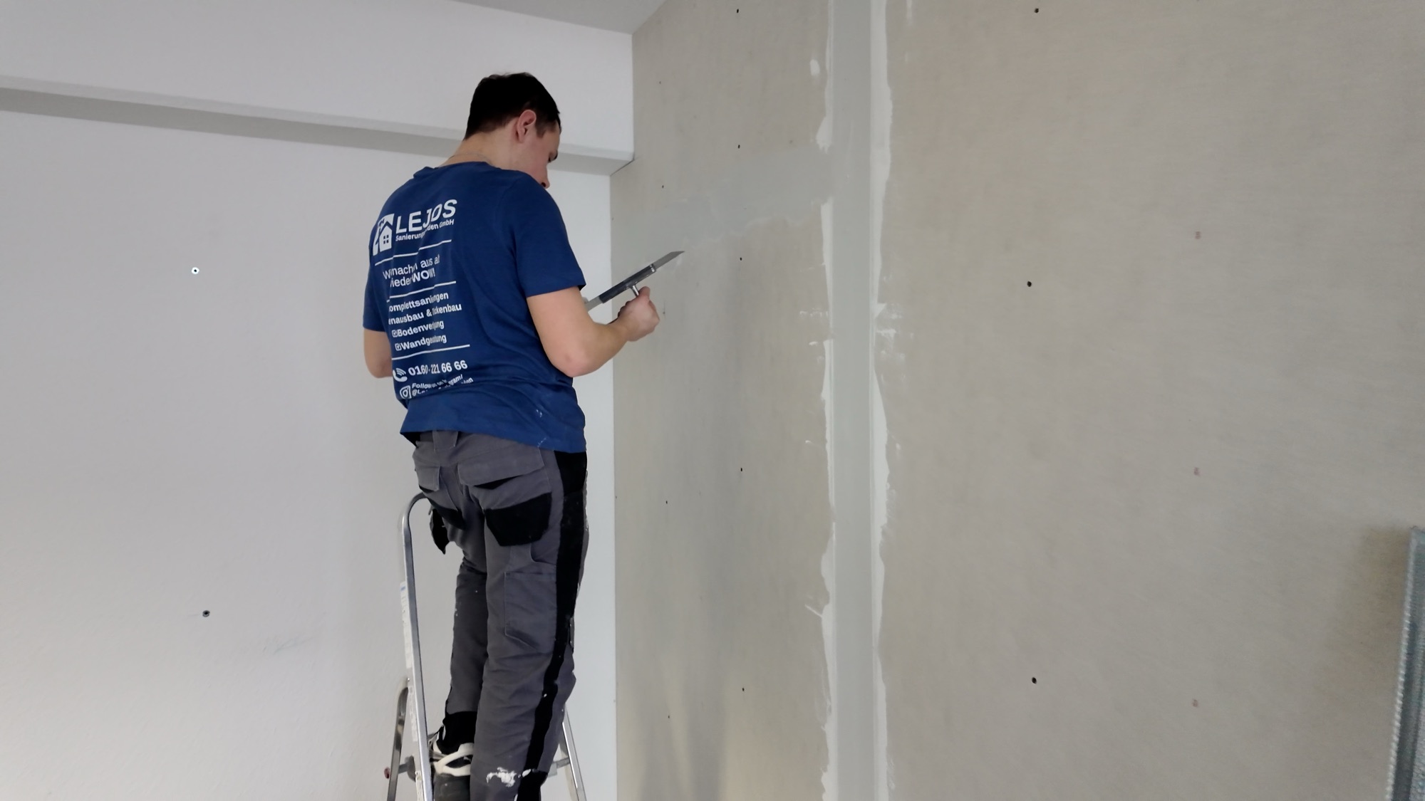 Monteur der LEJOS Sanierungshelden spachtelt eine neue Trockenbauwand